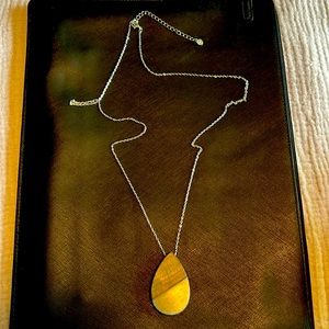 Maurice’s long silver necklace with wood tear shaped accent piece.